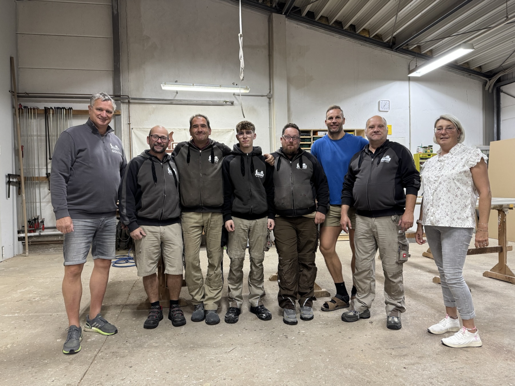 Ein Teil des Teams der Tischlerei Crölle steht gemeinsam in der Schweriner Werkstatt.
