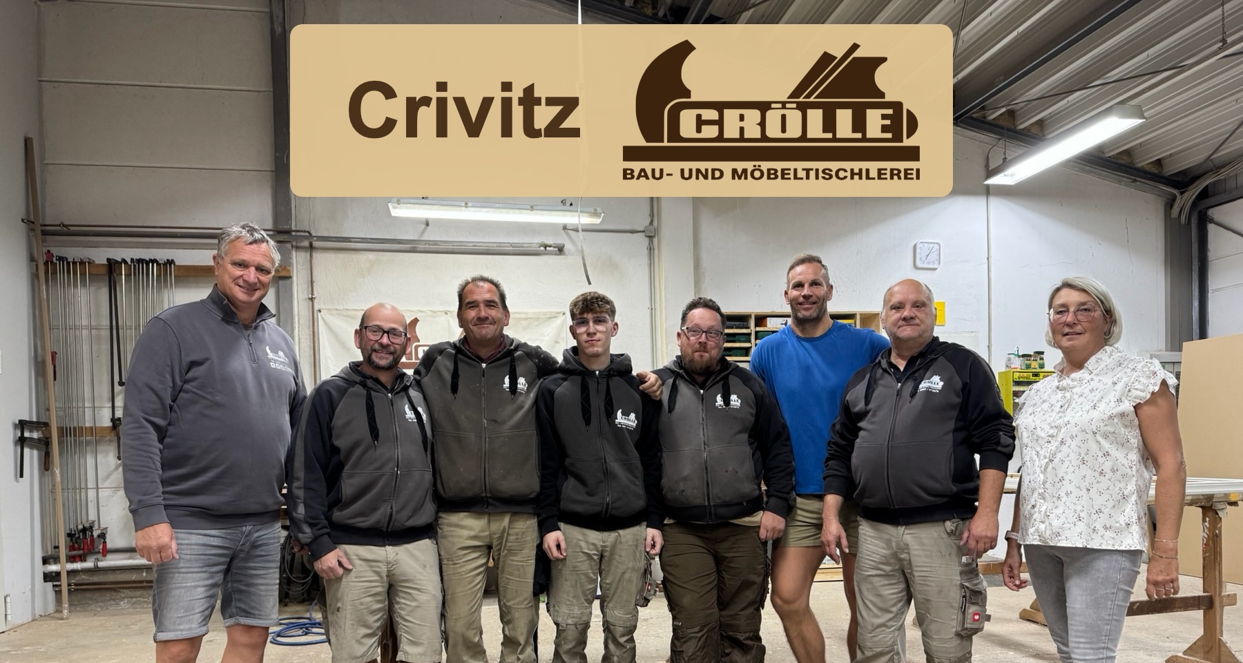 Ein Teil des Teams der Tischlerei Crölle in der Werkstatt in Schwerin; darüber Crölle-Logo und Schriftzug Crivitz